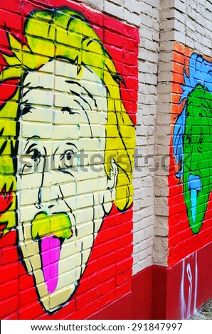Chernogolovka, Moscow, Russia - June 25, 2015: Colorful portrait of Einstein painted on a brick wall in Chernogolovka. Albert shows tongue. The popular image of the famous physicist. Graffiti.