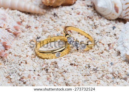 diamond ring with seashells and net in beach sand,Celebration Valentine\'s day on beach, rings on shell