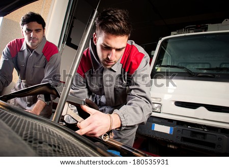 Mechanics at work. Mechanics at work on a car engine.