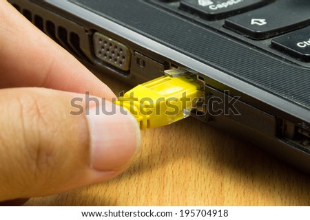 human hand with network cable prepare connect to laptop computer