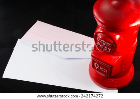 red ceramic postbox with envelopes  isolate on black background