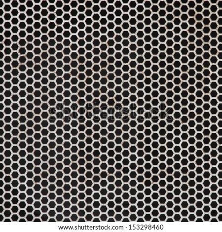Background sheet of metal covered with lines of holes