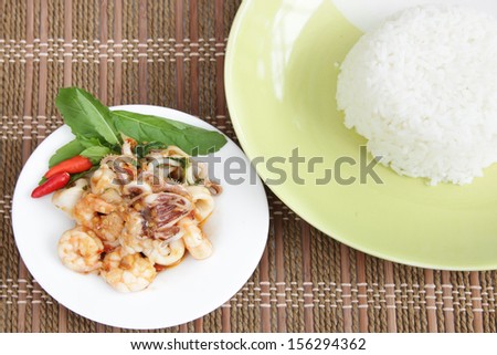 Food of Thailand fiery chili, garlic and basil sauce with fresh shrimp, squid. Served with jasmine rice.