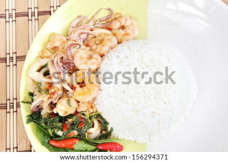Food of Thailand fiery chili, garlic and basil sauce with fresh shrimp, squid. Served with jasmine rice.