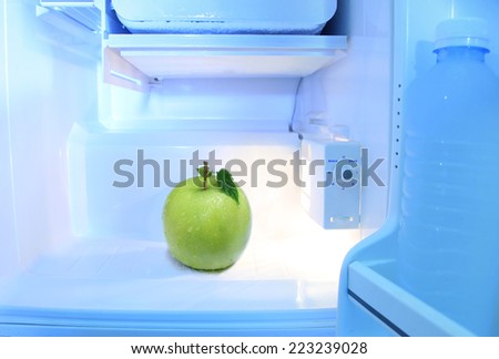 One green apple in open empty refrigerator concept of Diet for weight loss to maintain their shape, beautiful and healthy. Prevent harm to the body  opens the fridge.