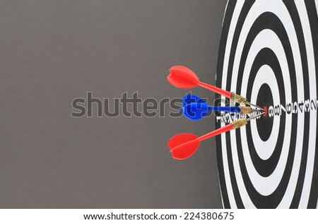 The goal of business is intended to accomplish as a team darts on dark gray background with arrows, middle target.