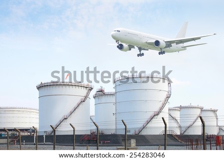 Fuel Storage Tank with white commercial airplane on sky background