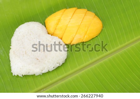 Thai popular dessert sweet sticky rice with mango on banana leaf.