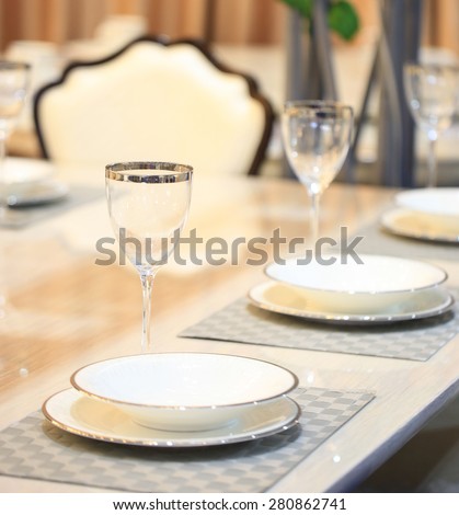 Place setting in an expensive haute cuisine restaurant dinner table Empty dish plate napkin & wine glass.