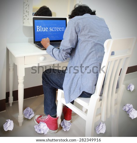 Student stressed computer user Business laptop or office notebook computer PC with OS critical error message on blue screen display. He will  loss data with out save file.