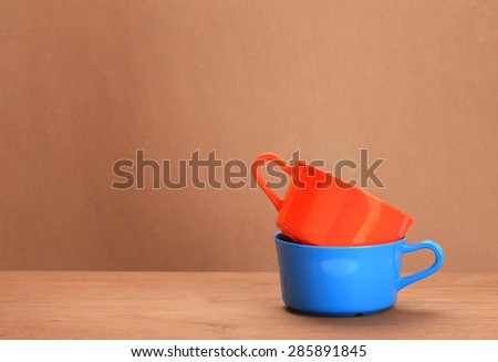 Blue empty cup of soup on a wooden floor with brown background.