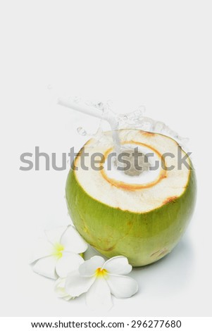 young coconut cut haft clear coconut juice splashing. The pure white light Invited to enjoy a relaxing vacation at the summer time. I isolated on white background