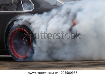 drift car motion spin rotating tire wheel with white smoke on the road.
