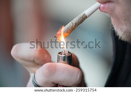 Man smoking marijuana cigarette soft drug in Amsterdam, Netherlands