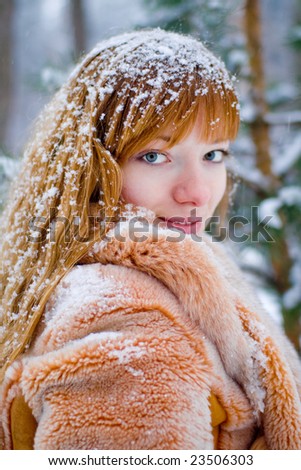Red-heared girl in fur coat outdoors - shallow DOF