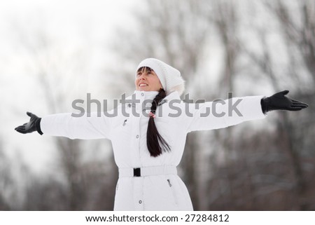 Winter portrait of a happy girl with arms spread - Shallow DOF