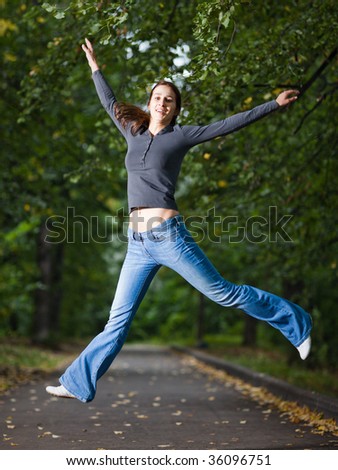 Jumping girl in a park alley - shallow DOF and little motion blur