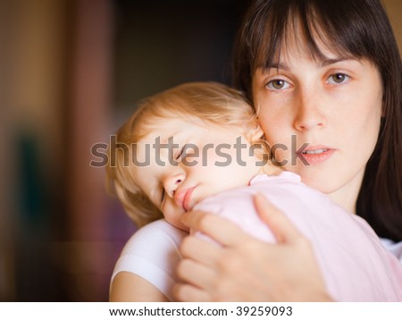 Sleepy little child with mom - shallow DOF, focus on woman's eyes