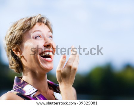 Laughing woman on a blue sky background - shallow DOF