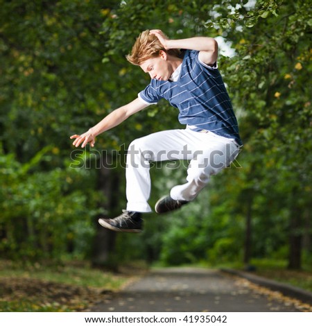Jumping man in a park alley - shallow DOF and little motion blur
