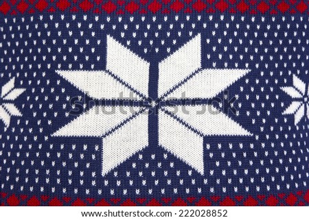 Knitted wool background with a beautiful norwegian or scandinavian pattern in blue, red and white.