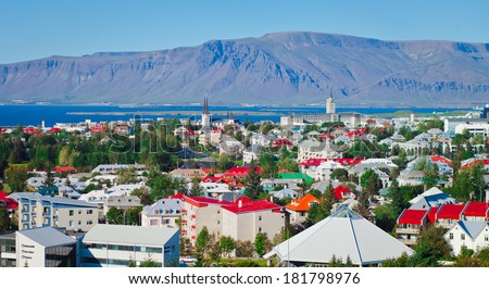 Beautiful super wide-angle aerial view of Reykjavik, Iceland with harbor and skyline mountains and scenery beyond the city, seen from the observation tower of Hallgrimskirkja Cathedral.