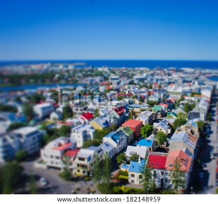 Beautiful TILT-SHIFT super wide-angle aerial view of Reykjavik, Iceland with harbor and skyline mountains and scenery beyond the city, seen from the observation tower of Hallgrimskirkja Cathedral.