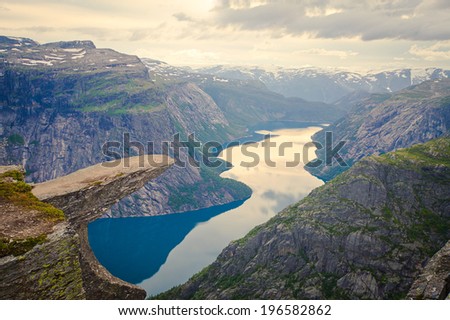 A vibrant picture of famous norwegian hiking place trolltunga the trolls tongue rock skjegedall with a tourist and lake ringedalsvatnet and mountain panoramic scenery epic view Norway A vibrant picture of famous norwegian hiking place trolltunga the trolls tongue rock skjegedall with a tourist and lake ringedalsvatnet and mountain panoramic scenery epic view Norway