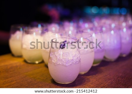 Beautiful line of different coloured cocktails on a open air party, tequila, martini, vodka, and others on decorated catering table on open air party