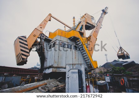 Yellow heavy excavator and bulldozer unloading road metal during road construction work