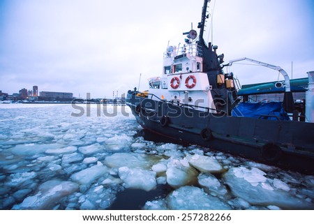 The Icebreaker ship trapped in ice tries to break and leave the bay between the glaciers