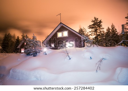 Beautiful scandinavian Finnish swedish norwegian wooden cottage cabin near slopes on a ski resort in the night time