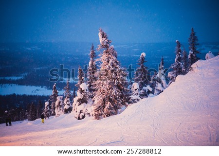 Beautiful vibrant night scandinavian winter aerial landscape with slopes, skiing resort and cottages with lights