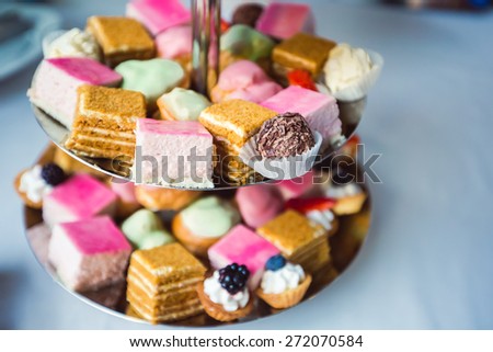 Beautiful multicolored decorated baked sweet tasty candy bar dessert on a party with happy people around