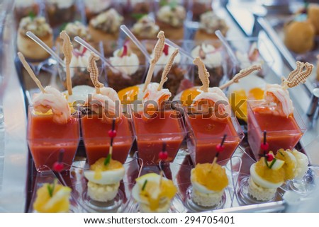 Beautifully decorated catering banquet table with different food snacks and appetizers with sandwich, caviar, fresh fruits on corporate event or wedding celebration