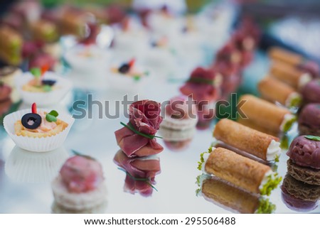 Beautifully decorated catering banquet table with different food snacks and appetizers with sandwich, caviar and fresh fruits on corporate party event or wedding celebration