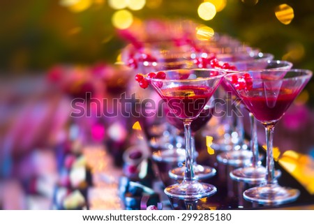 Beautiful line of different colored alcohol cocktails with mint on a open air party, tequila, martini, vodka, and others on decorated catering bouquet table on open air event, picture with tilt shift