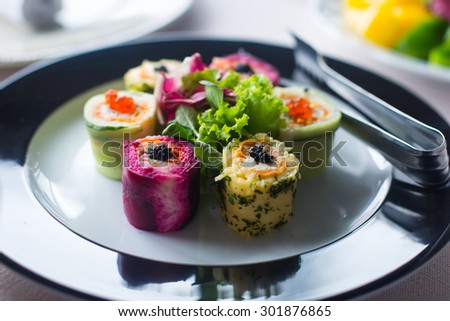 Beautifully decorated catering banquet table with different food snacks and appetizers with sandwich, caviar, fresh fruits on corporate birthday party event or wedding celebration