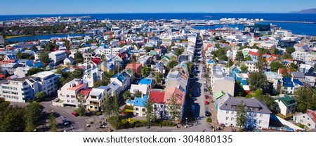 Beautiful super wide-angle aerial view of Reykjavik, Iceland with harbor and skyline mountains and scenery beyond the city, seen from the observation tower of hallgrimskirja