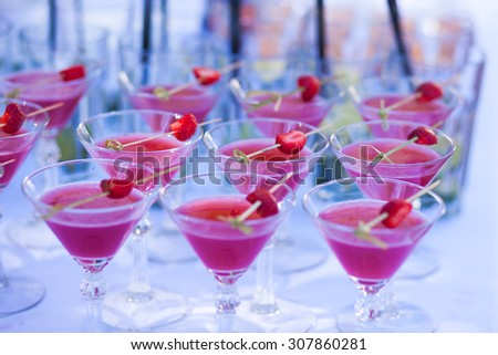 Beautiful row line of different colored alcohol cocktails with mint on a open air party, tequila, martini, vodka with bubbles,and others on decorated catering bouquet table on open air event, picture