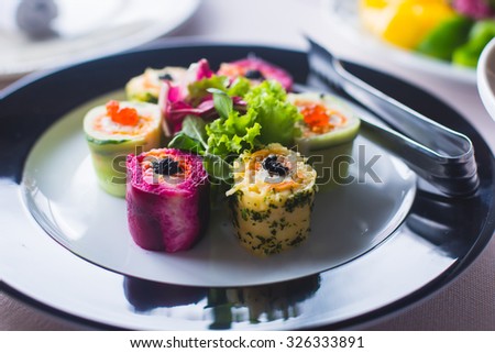 Beautifully decorated catering banquet table with different food snacks and appetizers with sandwich, caviar, fresh fruits on corporate birthday party event or wedding celebration