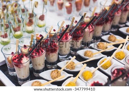Beautifully decorated catering banquet prepared table with different food snacks and appetizers with sandwich, caviar, fresh fruits on corporate christmas birthday party event or wedding celebration