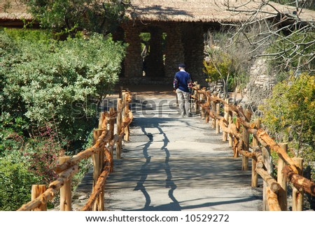 A older gentleman is taking a casual walk on one of the many garden trails.