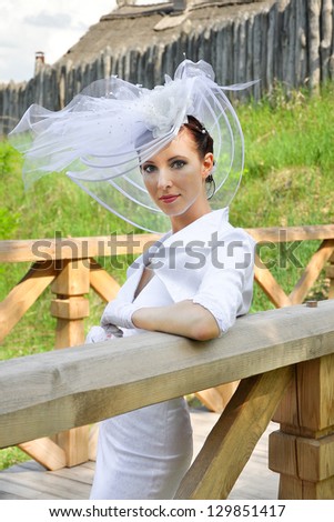 Beautiful woman in white dress and a hat in the country