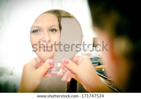 gentle bride looks in the mirror and smiling