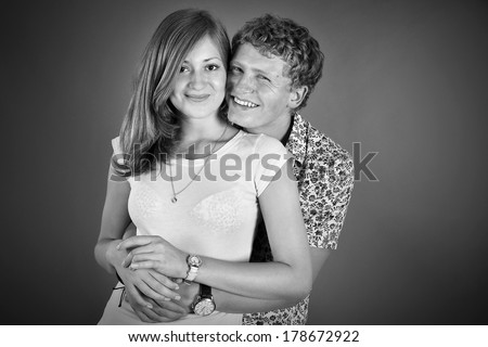 man hugging his girlfriend from behind. adolescents, the relationship. black-white