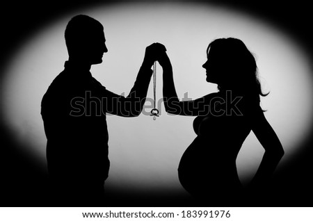 Pregnancy. mother and father holding a pacifier together. Romantic expectant parents