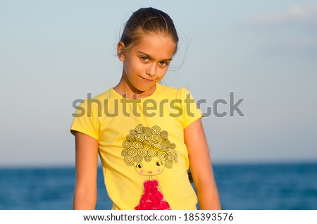 portrait of a beautiful girl at sunset. girl in yellow t-shirt on sky background