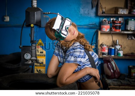 Jobs in the service station. The girl in the mask working at the bench. Hard work for women, fatigue, seven days a week