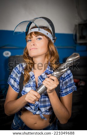 Girl in a mask of glass. Girl and drill. An employee in the garage. sexy worker
